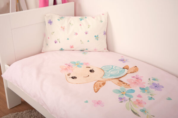 weiß-rosane babybest Schildkrötenbettwäsche auf weißen Bett