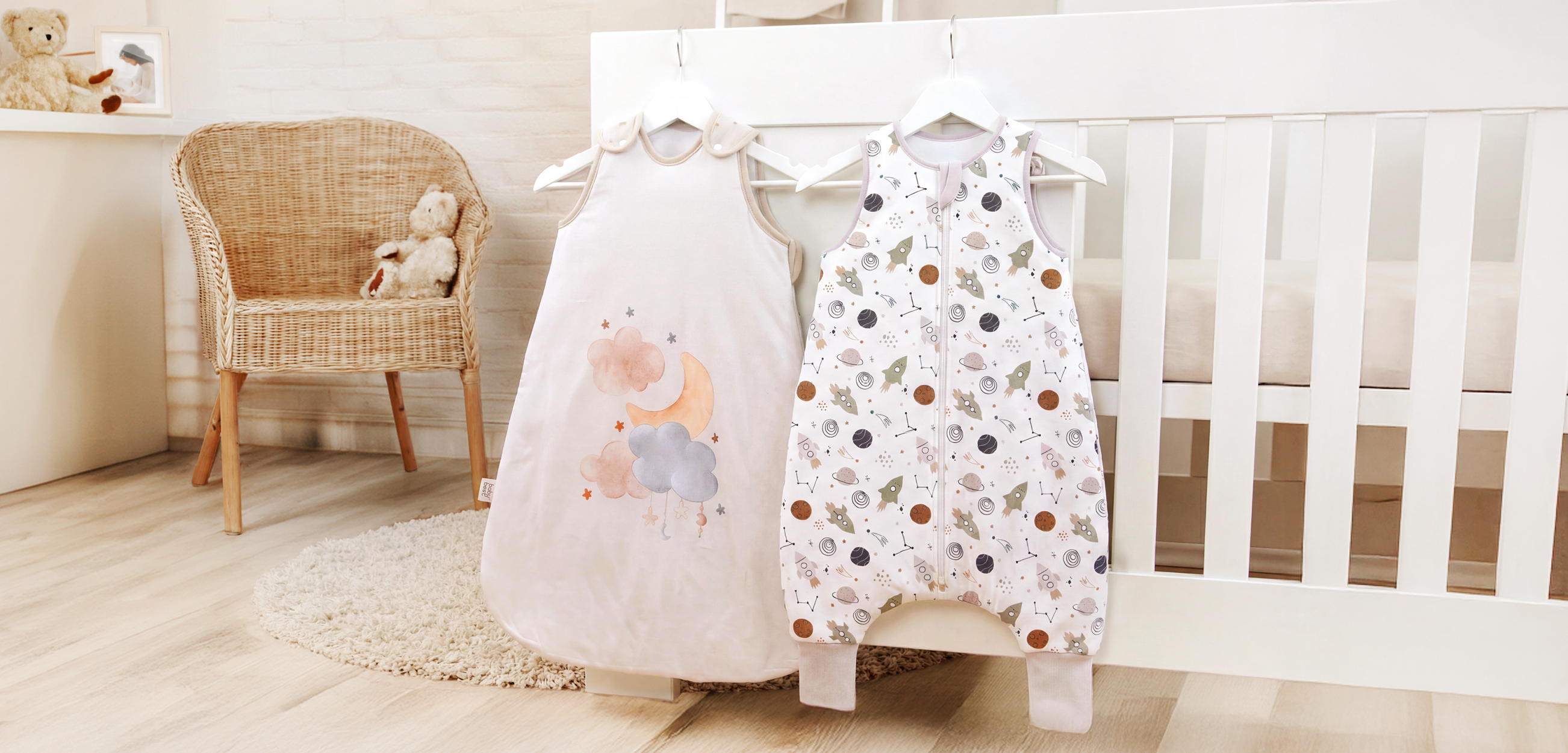 Unsere süßen Babyschlafsäcke hängend an einem Babybett.